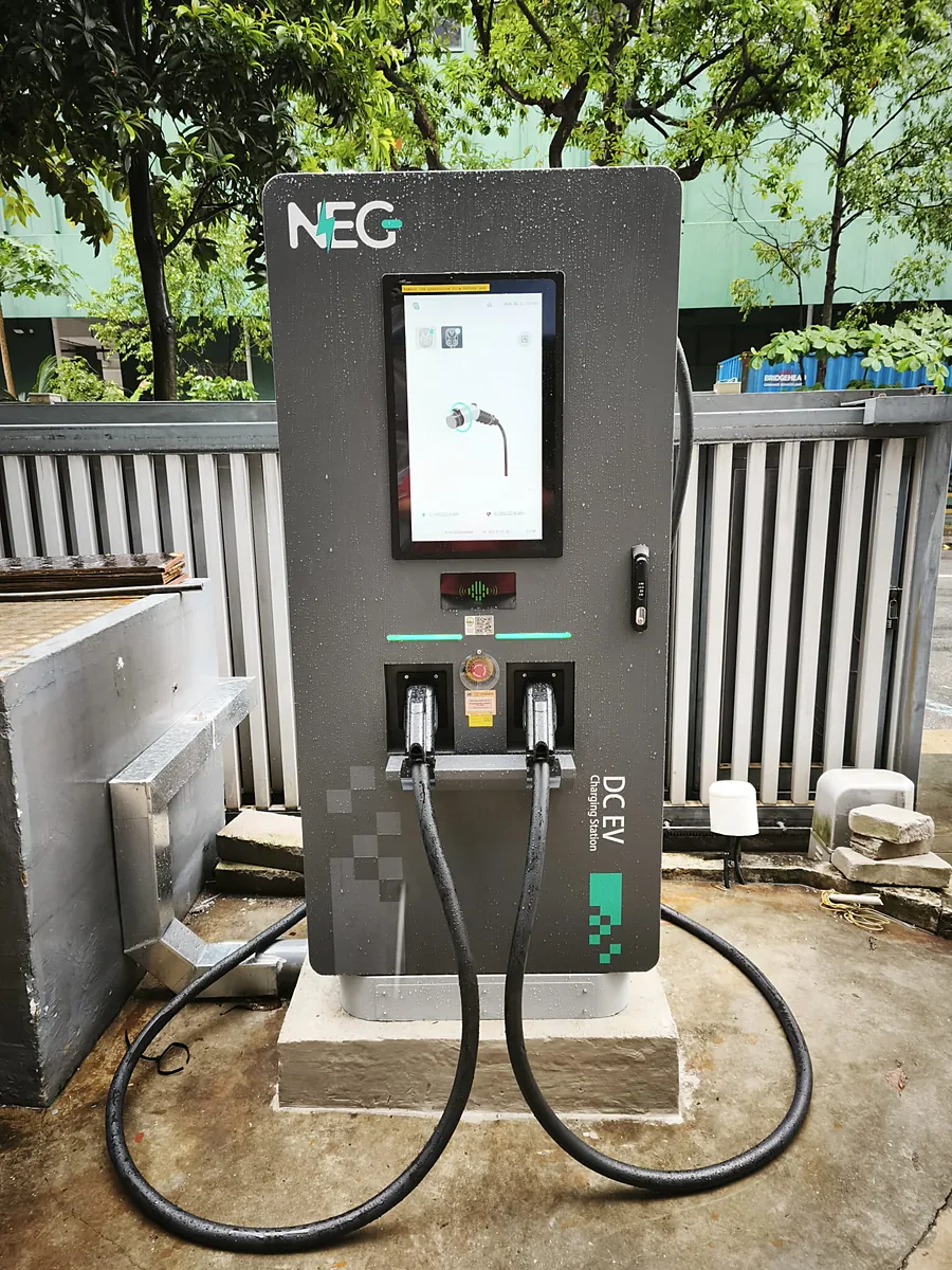 A NEG Power DC fast charger on one of our jobs, shot head-on — colour touchscreen, RFID reader and twin tethered cables running to the ground, on a concrete plinth.